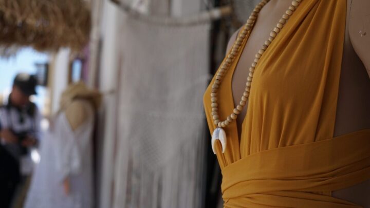 Artisans travaillent dans un atelier de mode italien, entourés de tissus et d’échantillons de cuir.
